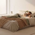 A person sleeping peacefully in a modern 2025 bedroom, illustrating the science of sleep quality with a subtle wearable sleep tracker.