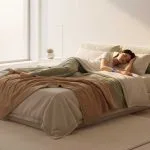 A person sleeping peacefully in a modern 2025 bedroom, illustrating the science of sleep quality with a subtle wearable sleep tracker.